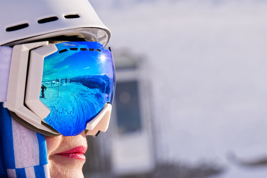 Portrait of woman in alps. woman in ski goggles at the ski resort. reflection in ski goggles