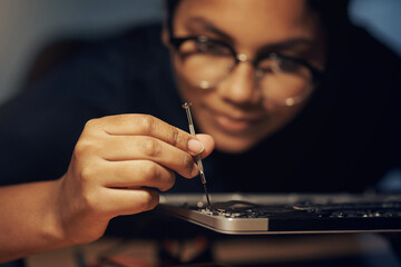 The best computer repair technician in town. Shot of a young technician using a screwdriver to repair computer hardware.