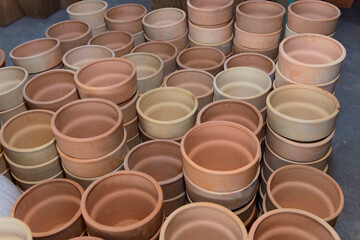 Stacks of various terracotta pots for plants. Pottery made on a Potter's wheel by hand.