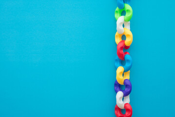 Colorful plastic block chain on blue background copy space. Business and finance strategy, teamwork, harmonious, business management, creative idea concept. Teamwork is key success to target.