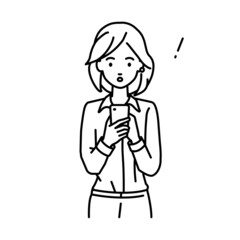 立ってスマートフォンを操作して何かに気づいて驚いたブラウスの女性