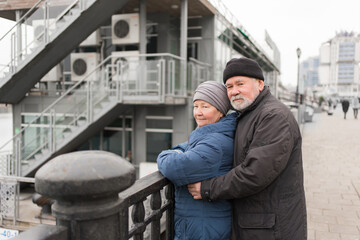 a happy elderly couple on a walk along the promenade. tourism and retirement travel. active and healthy old men and women.