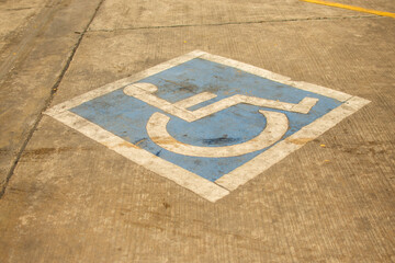 Disabled parking symbol on cement floor.