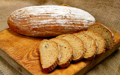 Bread loaf with powder. Slices of loaf in the foreground.