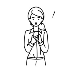 立ってスマートフォンを操作して何かに気づいて驚いたブラウスの女性