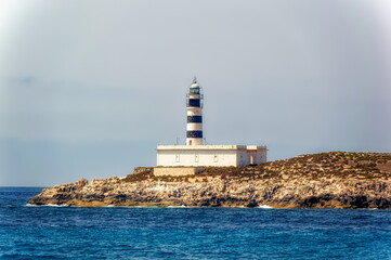 Fototapeta na wymiar Old lighthouse at small Ballearic island close to island of Formentera, Spain.