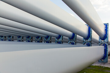 The blades of the wind stations are fixed and piled on the pier before departure from the city of...
