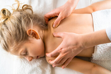Fototapeta na wymiar a woman gives a massage to a little girl, children's massage, prevention of scoliosis, osteopathy