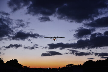 A plane landing at sunset