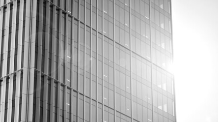 Urban abstract - windowed wall of office building. Detail shot of modern business building in city. Looking up at the glass facade of a skyscraper. Black and white filter.