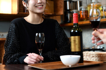 笑顔でお酒と食事を楽しむアジア人女性と男性（カップル）
