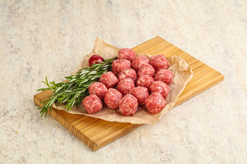 Raw uncooked beef meatballs served rosemary