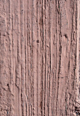 Close-up of a wooden board painted with beige paint as an abstract textural background. A board with peeling, scratched and sun-bleached brown paint. Texture of old painted boards