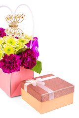 gift box with a bow on the background of a bouquet of flowers on a white background