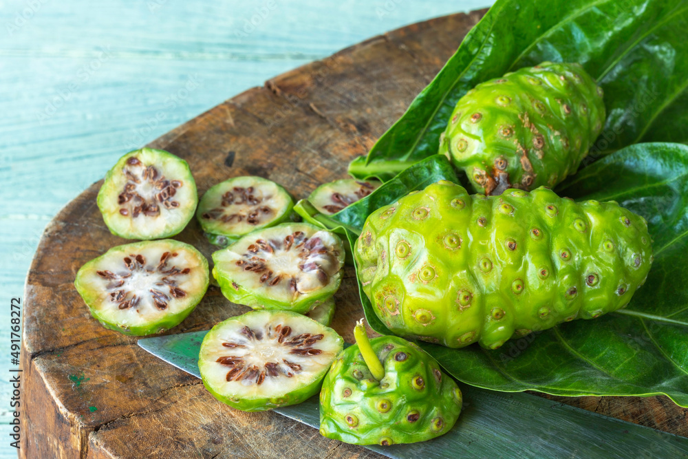 Wall mural fresh noni fruit and leaves.