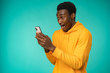 Afro american man using smartphone over isolated mint background