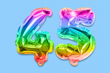 Rainbow foil balloon number, digit forty five on a blue background. Birthday greeting card with inscription 45. Anniversary concept. Numerical digit. Celebration event, template.