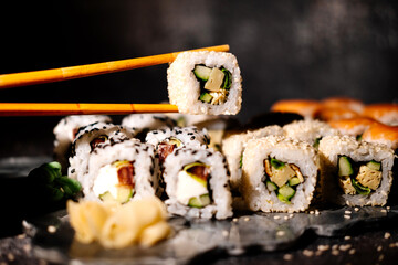 A photo of sushi that you can use for menus and advertisements. Sushi and rolls on a dark background.