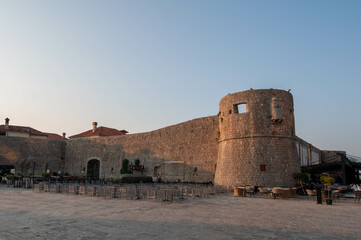 a fortress on the shore of the sea in the sunrise light