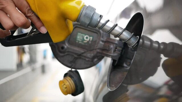Car refueling on the petrol station. male employees controlled the fuel pump with Fuel nozzles adding gasoline fuel in car at a pump gas station. 