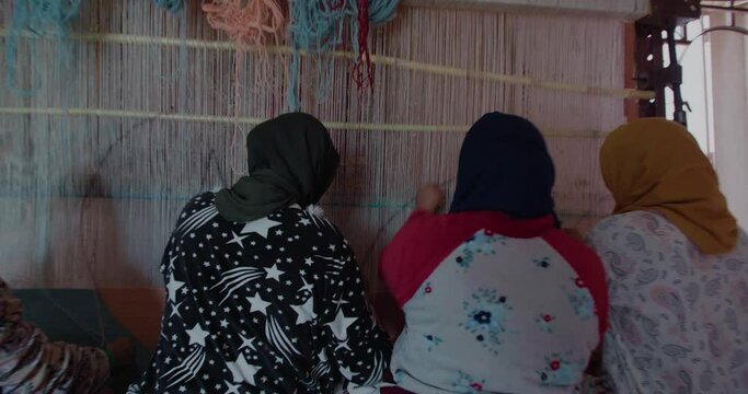 women making traditional carpets in morocco