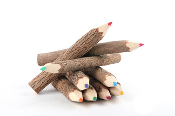 Colorful crayons made of rough and unprocessed wood isolated on white
