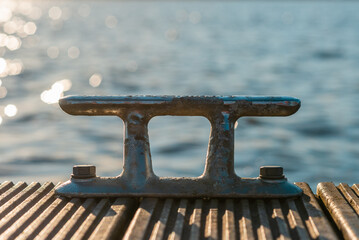 Old cliet from the shore yacht on a wooden tick background with sunset sunlights in the...