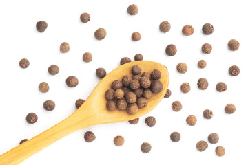 Spice Allspice in wooden spoon and big size bunch on white background isolated. Flat lay. Macro. Healthy diet concept