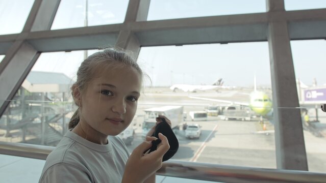 Children girl kid caucasian at airport with wearing protective medical mask on head against background of plane. Concept health virus protection coronavirus epidemic sars-cov-2 covid-19 2019-ncov.