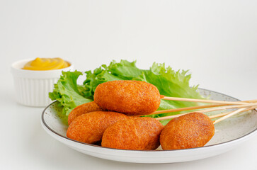 Traditional American fast food. Corn dogs on white background with mustard. Copy space