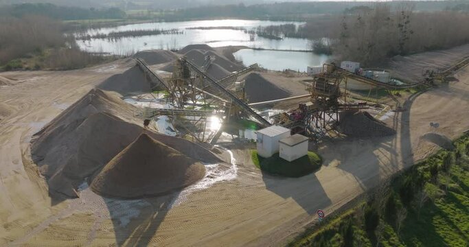 Aerial shot of machines and trucks working in a sand quarry, in France. Those are extracting and  filtering the sand.