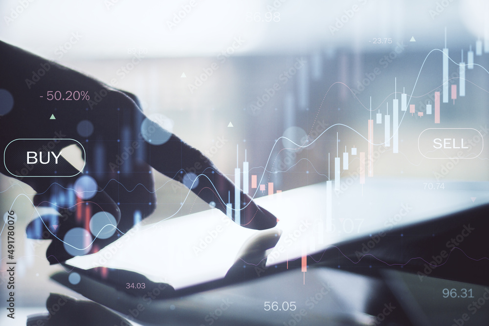 Poster close up of backlit hand using tablet at desktop with glowing forex chart on blurry background. trad