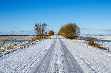 Obraz premium Winter landscape in the countryside. Road going into the distance