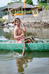 Portrait Beautiful girl paddles on a wooden canoe, Bali, Indonesia