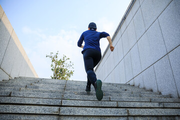 Sports woman running up stairs in city