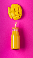bottled mango juice and portion of fresh mango in pieces isolated from the background. Copy space