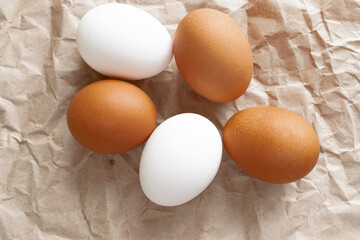 Easter layout. Two white and three brown eggs are lying on crumpled paper. Easter. Holiday. Sale of eggs. Cooking. Calendar.