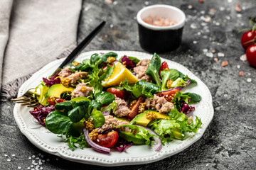 Tasty tuna salad with lettuce, cherry tomatoes, avocado and red onions. superfood concept. Healthy, clean eating concept. Vegan or gluten free diet. Top view