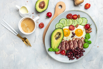 Fototapeta na wymiar Ketogenic diet meal avocado, fried eggs, bacon, and beans. Healthy nutritious paleo keto breakfast diet lunch. banner, catering menu recipe place for text, top view