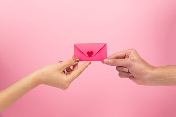 woman holding heart envelope on pink background