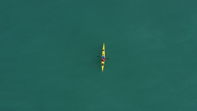 Single seat canoe rowing over a shallow lagoon, Aerial view.
