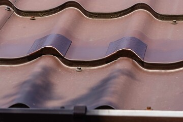 Repair of holes on metal roof with TechnoNIKOL self-adhesive waterproofing bituminous tape....