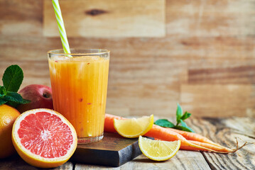 Fruit juice served in glass.V arious fresh fruit juice citrus apple and carrots served in glass on wooden table. Fruit healthy juice for detox.