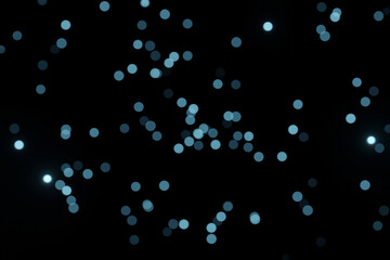 Defocused bokeh lights on black background, an abstract naturally blurred backdrop for Valentines Day or birthday party. Festive light texture. Violet blue garland in blur. Color 2022