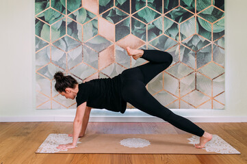 sportliche Frau in schwarz macht Yoga im Studio horizontal