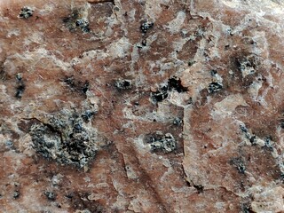 Red stone relief texture pattern close-up.