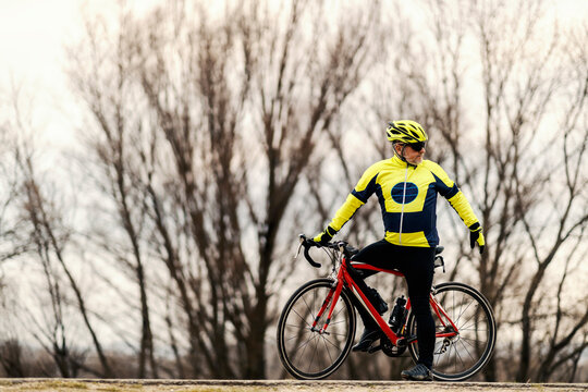 A senior bicyclist on a bike looking over the shoulder.