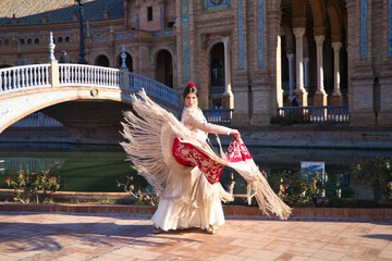 Flamenco dancer, woman, brunette and beautiful typical spanish dancer is dancing with a red manila...