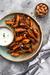 Honey garlic butter roasted carrots on a concrete background. Roasted carrots prepared with garlic...