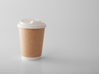 Brown takeaway paper cup with white plastic lid. .